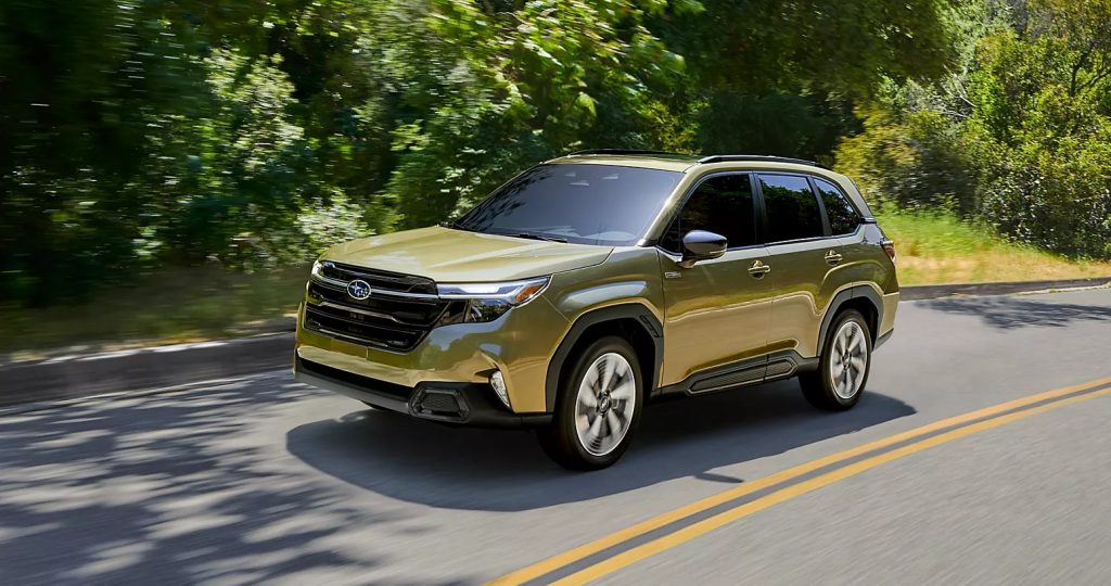Green Subaru Forester SUV driving on a forest road.