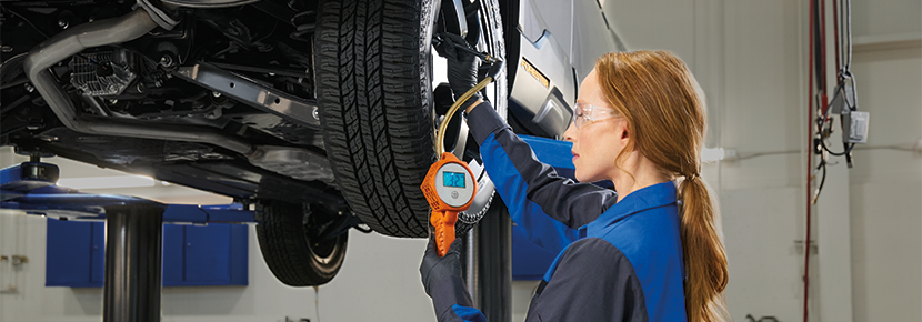 A Subaru technician checking tire pressure. | DELLA Subaru of Plattsburgh in Plattsburgh NY