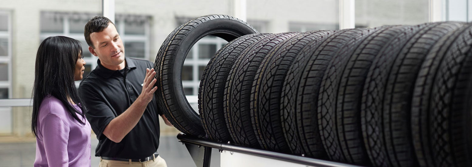 Subaru service representative showing customer a tire. | DELLA Subaru of Plattsburgh in Plattsburgh NY
