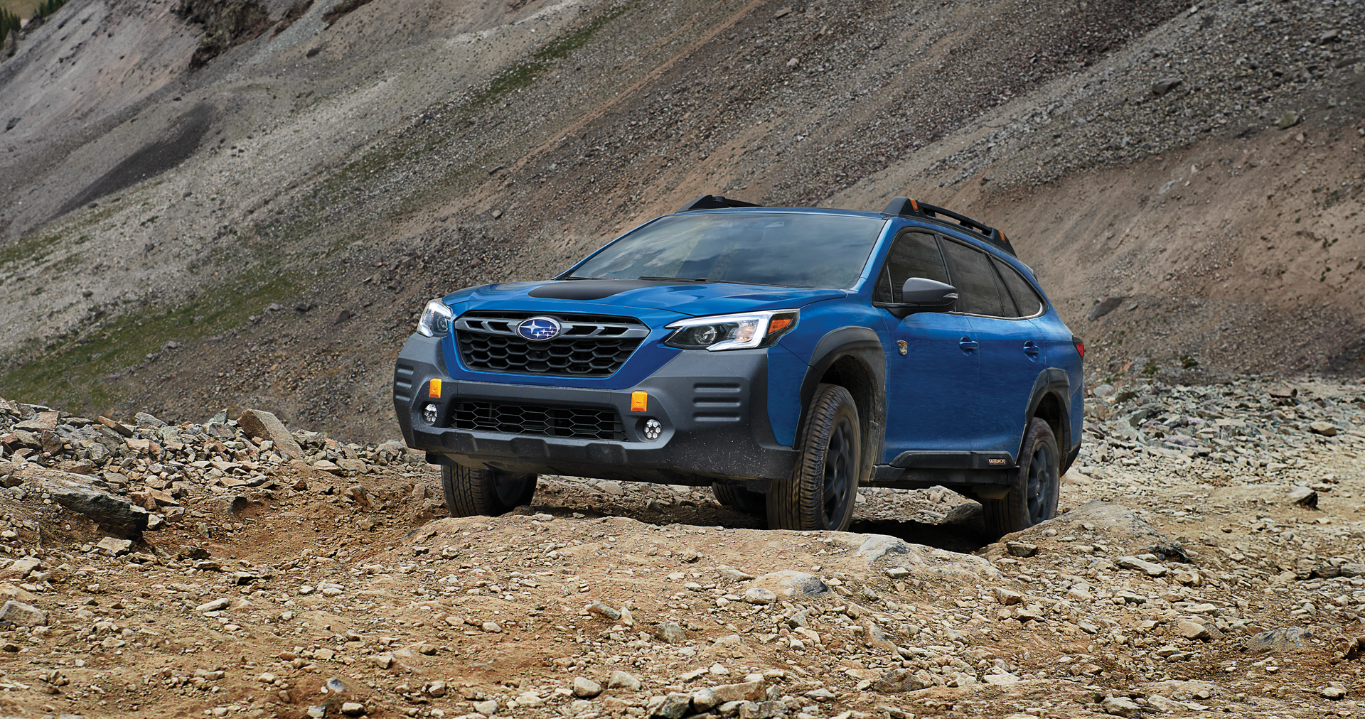 A 2023 Outback Wilderness driving on a trail in the mountains. | DELLA Subaru of Plattsburgh in Plattsburgh NY